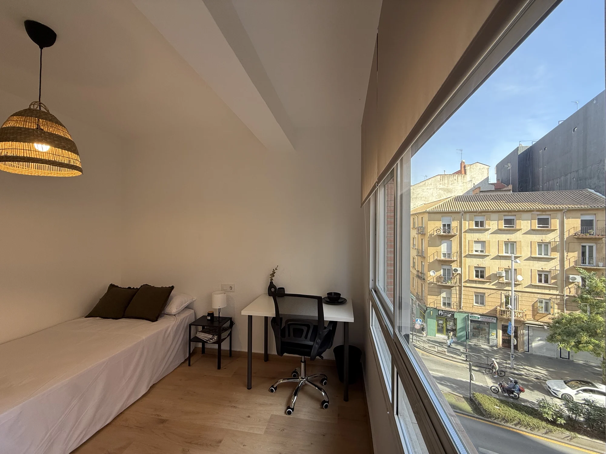 Habitación EGO ROOMS de tonos cálidos con lámpara de fibras naturales y vistas a la calle