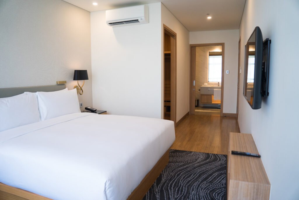 small hotel room interior with double bed and bathroom